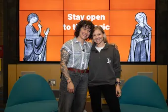 Jessie Contour and Kelcey Gray stand together as they present their game and typography project, Dropcaps.