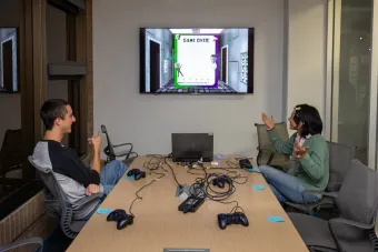 Two Arts and Entertainment Technologies students engage in a student-built video game