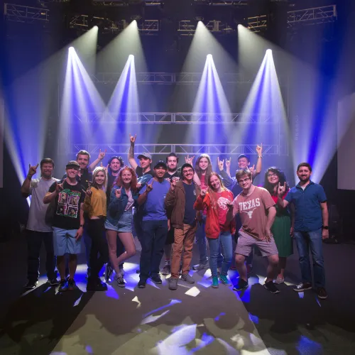 students show the UT hook em sign in a concert lighting demo room