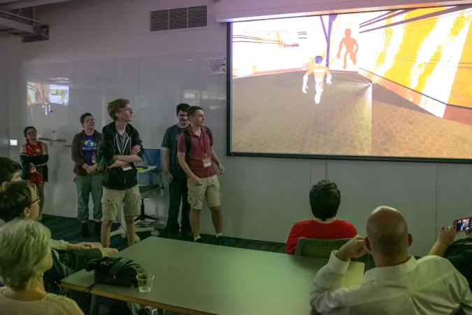 a group of high school students present their original video game to their parents at the 2019 SDCTx Game Design Summer Institute showcase